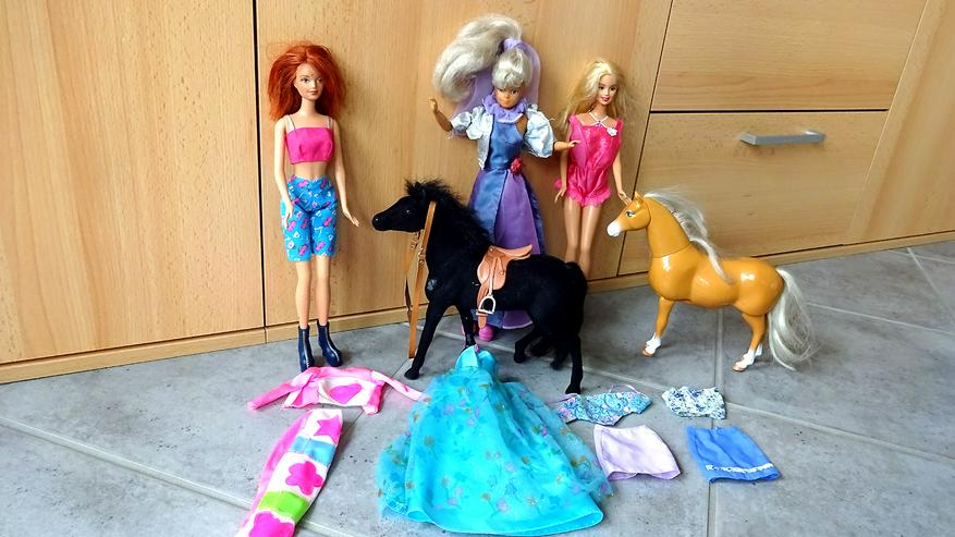 3 Barbiepuppen, 2 Barbiepferde und 4 Kleider.