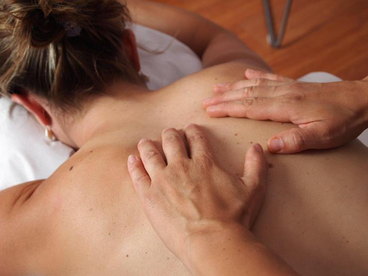 Männlicher Masseur bietet sinnliche Wellness-Massage für Frauen